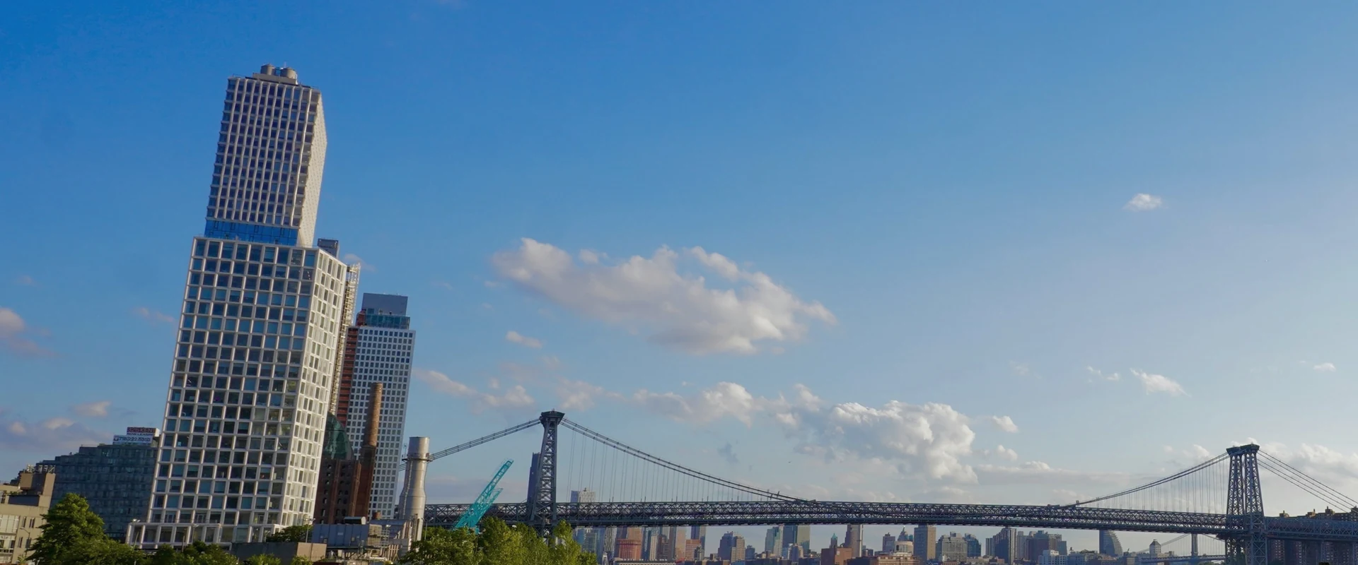Brooklyn waterfront, timber pier remains and Williamsburg Bridge across the East River